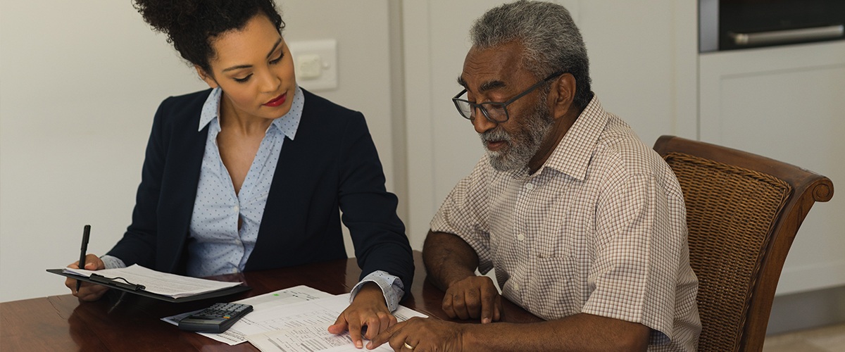 a female realtor going over some documents with an older man